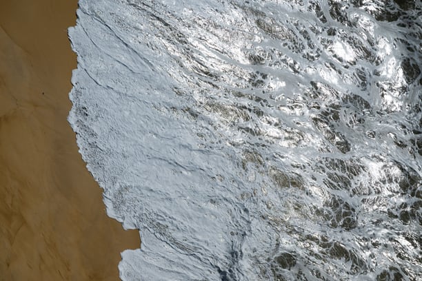 Aerial view of waves breaking on a coastal shoreline