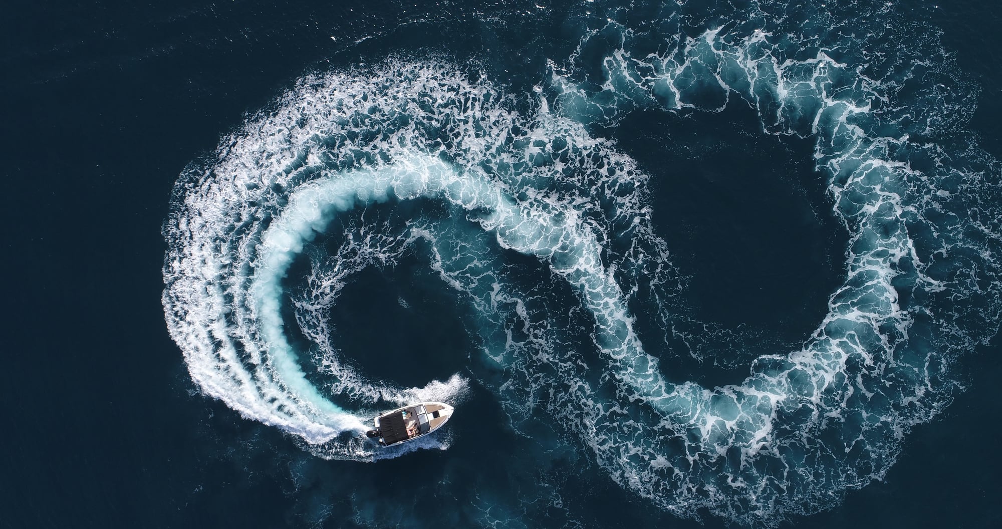 Aerial shot of a powerboat turning on open water